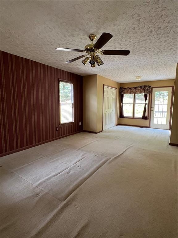 11 Seabreeze Way, Dawsonville, GA 30534 - empty room with healthy amount of natural light, ceiling fan, a textured ceiling, light colored carpet, and wooden walls