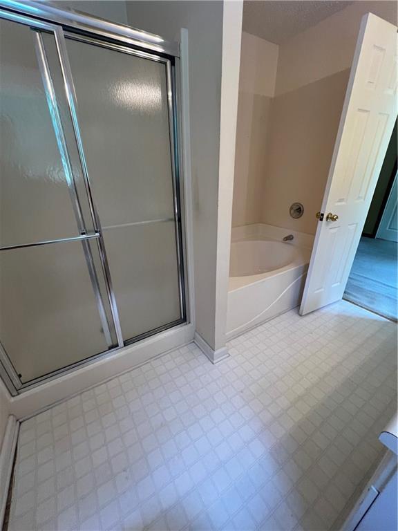 11 Seabreeze Way, Dawsonville, GA 30534 - bathroom with tile patterned floors, a bath, and a stall shower