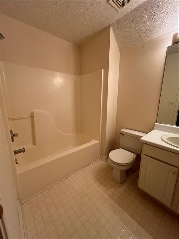 11 Seabreeze Way, Dawsonville, GA 30534 - bathroom featuring tile patterned floors, vanity, washtub / shower combination, and a textured ceiling
