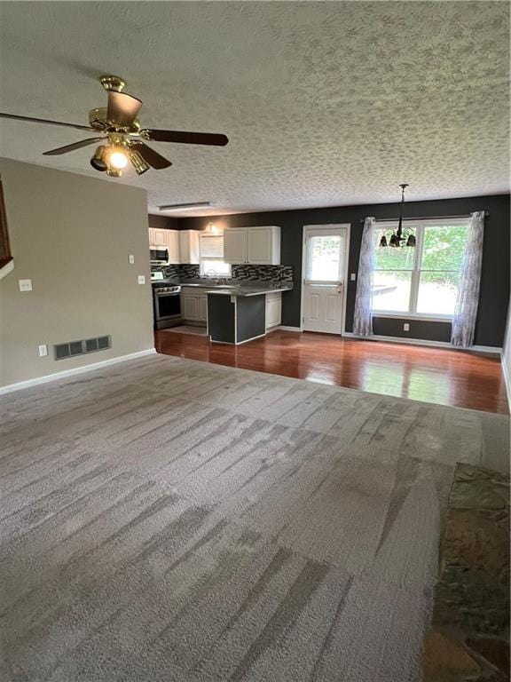 11 Seabreeze Way, Dawsonville, GA 30534 - kitchen featuring stainless steel appliances, open floor plan, dark colored carpet, white cabinets, and a textured ceiling