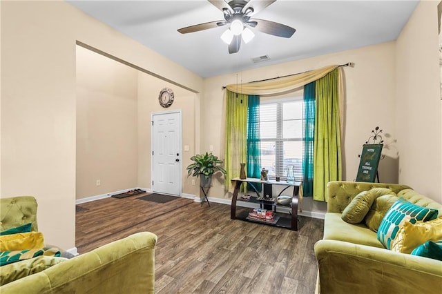 interior space featuring baseboards, visible vents, ceiling fan, and wood finished floors