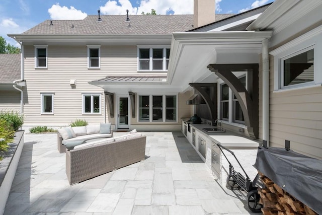 back of property with an outdoor living space, sink, a patio, and an outdoor kitchen