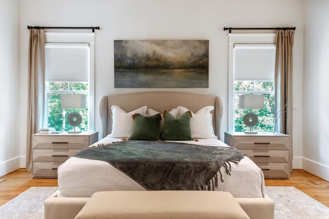 bedroom with multiple windows and light hardwood / wood-style flooring