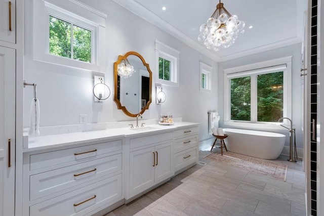 bathroom featuring vanity, an inviting chandelier, a bathing tub, and crown molding