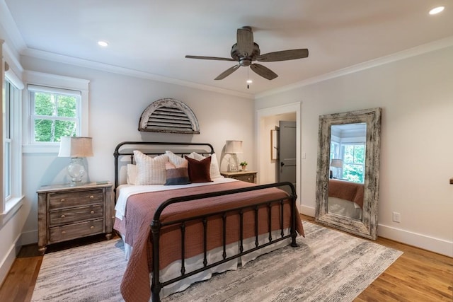 bedroom featuring ceiling fan, crown molding, and light hardwood / wood-style floors