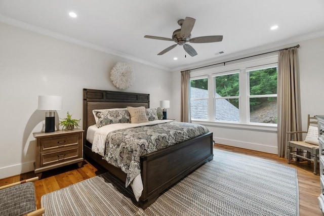 bedroom with ceiling fan, ornamental molding, and light wood-type flooring