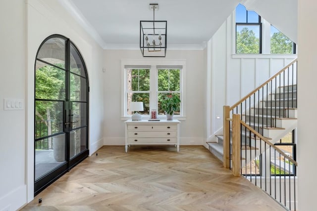 doorway featuring light parquet flooring, a healthy amount of sunlight, and ornamental molding