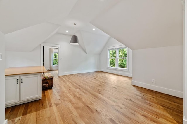 bonus room with a wealth of natural light, light hardwood / wood-style flooring, and lofted ceiling