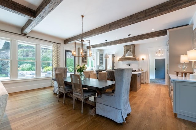 dining room with a chandelier, beam ceiling, and light hardwood / wood-style floors