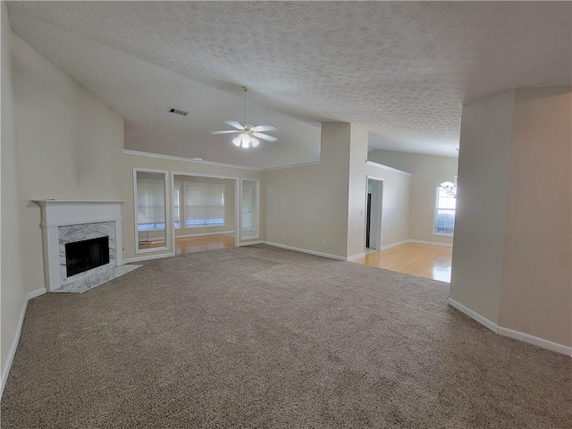 unfurnished living room with lofted ceiling, light carpet, ceiling fan, and a fireplace