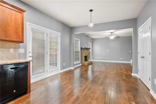 unfurnished living room featuring a fireplace, dark hardwood / wood-style flooring, and ceiling fan