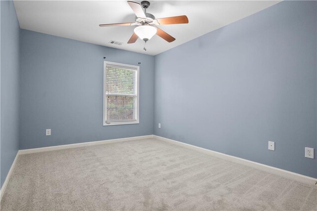 empty room featuring ceiling fan and carpet