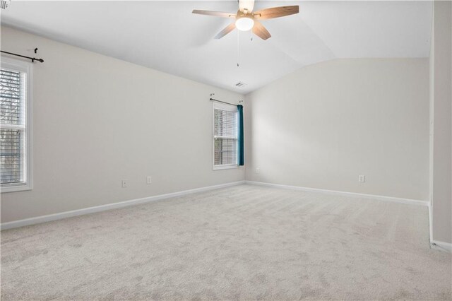 carpeted empty room featuring ceiling fan and vaulted ceiling