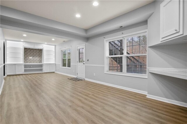 interior space featuring built in features and light hardwood / wood-style floors