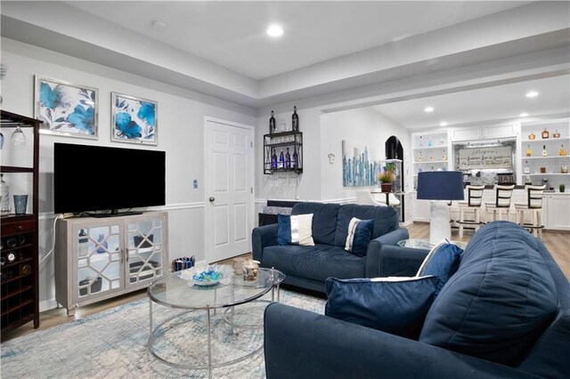 living room featuring built in shelves and light hardwood / wood-style flooring