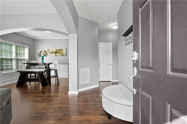 entryway with dark wood-type flooring and ornamental molding