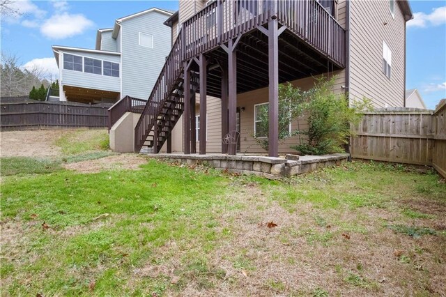 back of property with a lawn and a wooden deck