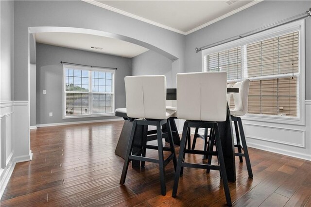 dining space featuring dark hardwood / wood-style flooring and ornamental molding