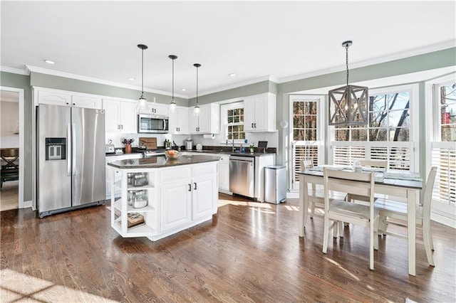 kitchen featuring stainless steel appliances, a center island, hanging light fixtures, and white cabinets