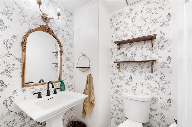 bathroom featuring crown molding, sink, and toilet