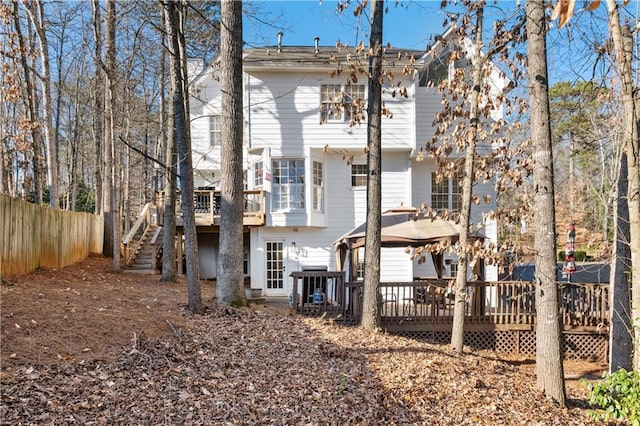 rear view of property featuring a wooden deck and a gazebo