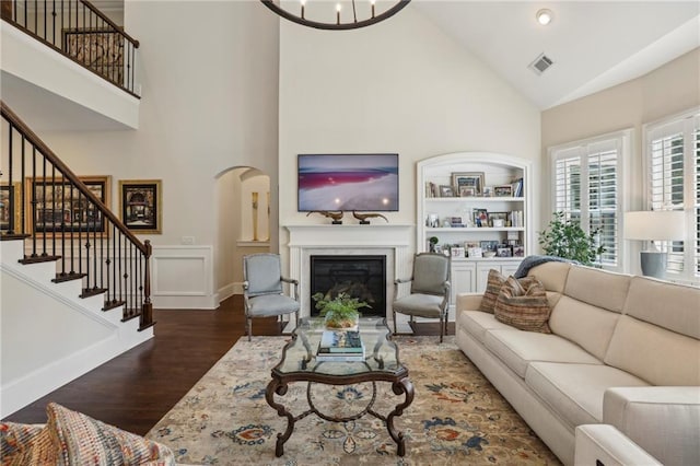 3005 Evelyn Ln, Alpharetta, GA 30004 - living area featuring high vaulted ceiling, wood finished floors, built in features, stairway, and a glass covered fireplace