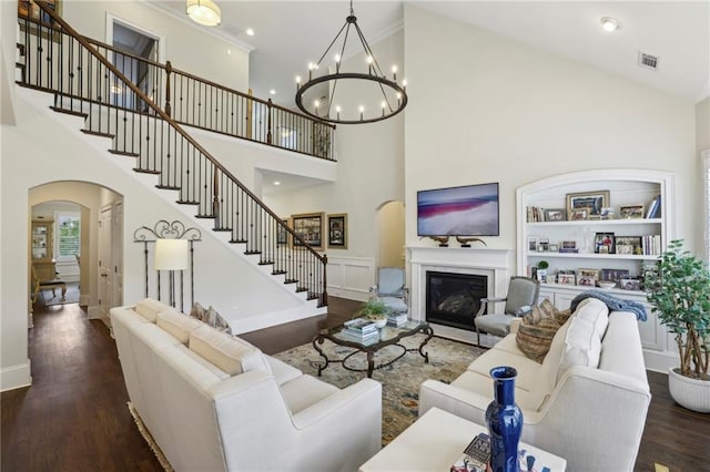 3005 Evelyn Ln, Alpharetta, GA 30004 - living room with a high ceiling, arched walkways, stairway, wood finished floors, and a glass covered fireplace