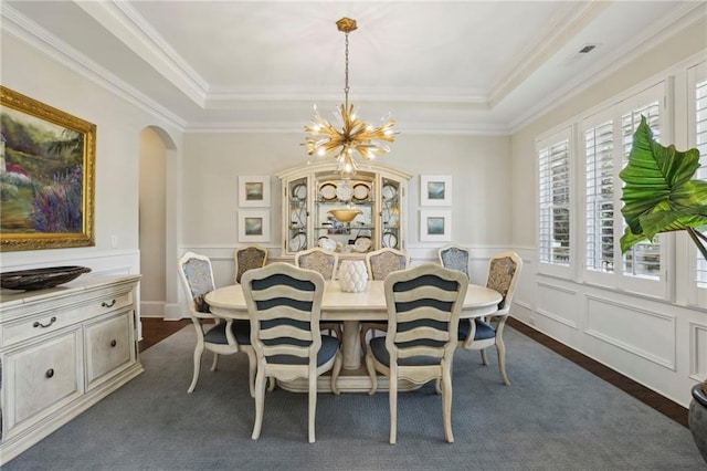 3005 Evelyn Ln, Alpharetta, GA 30004 - dining area featuring arched walkways, a tray ceiling, a chandelier, dark wood finished floors, and a decorative wall