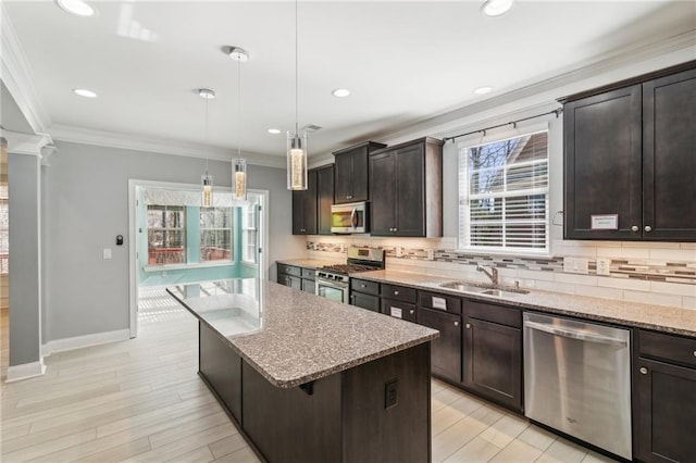 kitchen featuring sink, dark brown cabinets, hanging light fixtures, appliances with stainless steel finishes, and a kitchen island