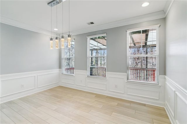 unfurnished dining area featuring ornamental molding and hardwood / wood-style floors