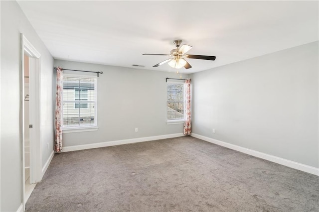 carpeted spare room with ceiling fan