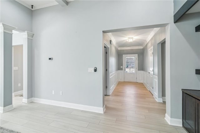 corridor with ornamental molding and light hardwood / wood-style floors