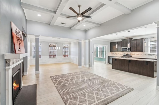 living room featuring beamed ceiling, coffered ceiling, light hardwood / wood-style floors, and decorative columns