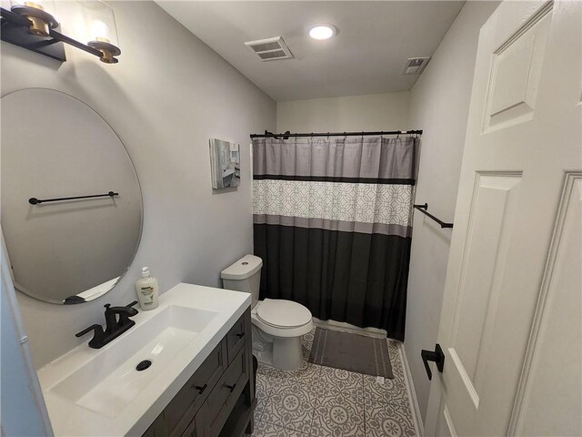 bathroom with tile patterned flooring, vanity, toilet, and curtained shower