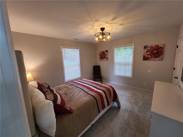 carpeted bedroom featuring a notable chandelier