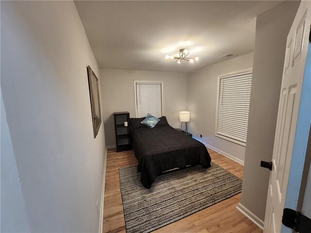 bedroom featuring a chandelier and light hardwood / wood-style floors