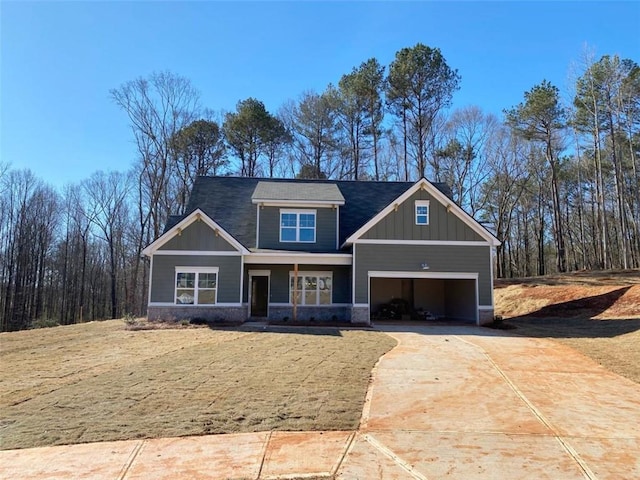 craftsman inspired home featuring a garage, concrete driveway, board and batten siding, and stone siding