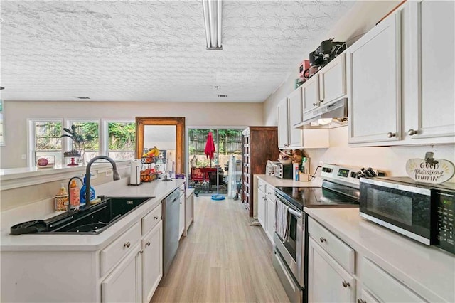 4161 Magnolia Glen Walk, Norcross, GA 30093 - kitchen featuring stainless steel appliances, under cabinet range hood, light countertops, and white cabinetry