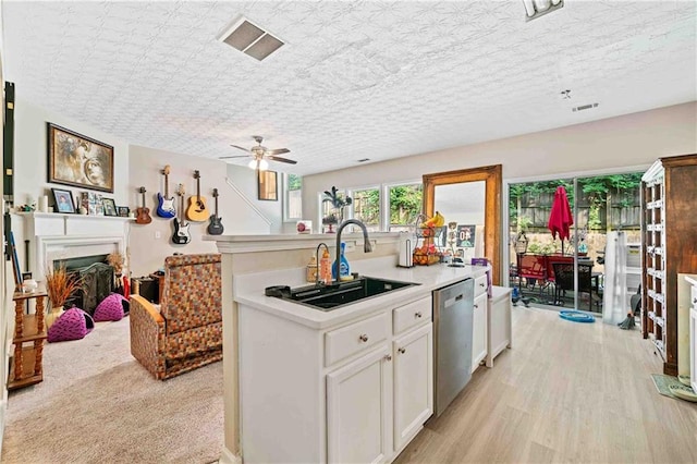4161 Magnolia Glen Walk, Norcross, GA 30093 - kitchen featuring stainless steel dishwasher, a sink, a kitchen island with sink, light countertops, and white cabinetry