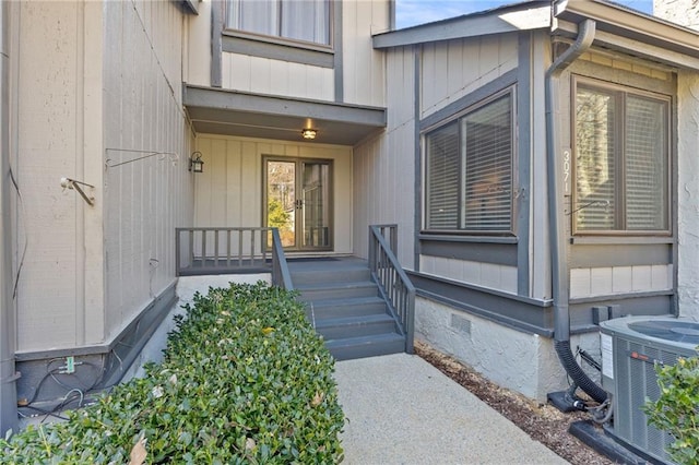 view of exterior entry featuring crawl space, covered porch, and central AC unit