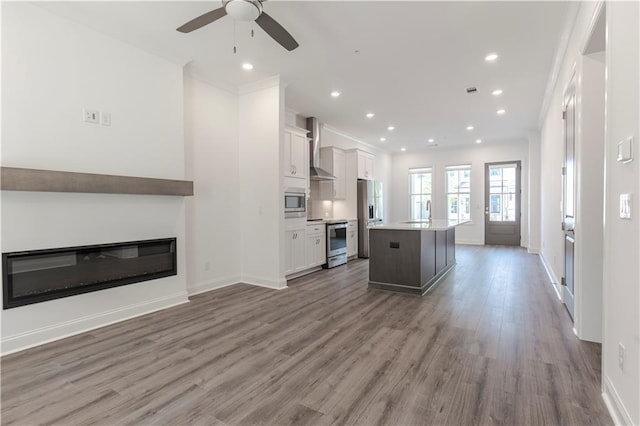 4948 Sudbrook Way, Peachtree Corners, GA 30092 - kitchen featuring a glass covered fireplace, appliances with stainless steel finishes, wall chimney exhaust hood, and open floor plan