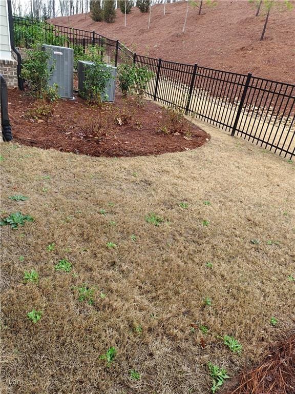 view of yard with fence and central air condition unit