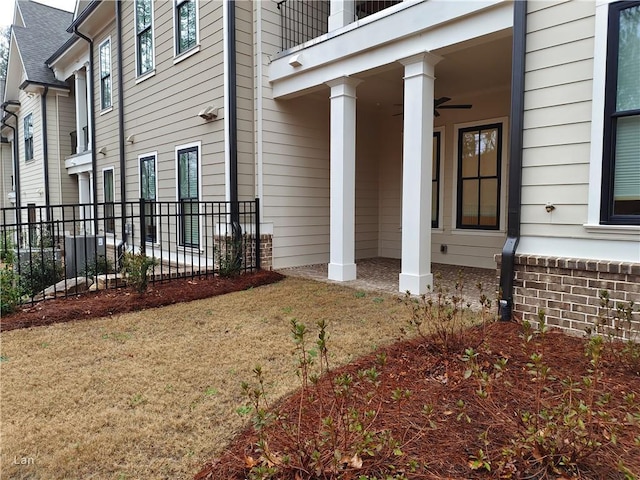 entrance to property featuring fence and a yard