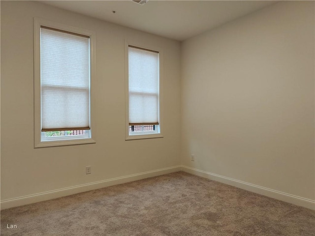 carpeted spare room with baseboards