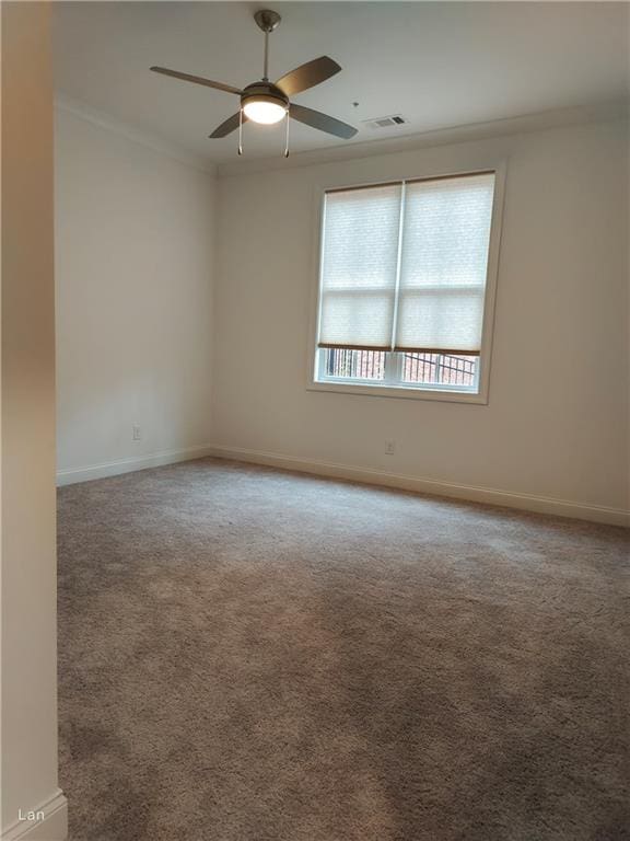 carpeted spare room with visible vents, crown molding, and baseboards