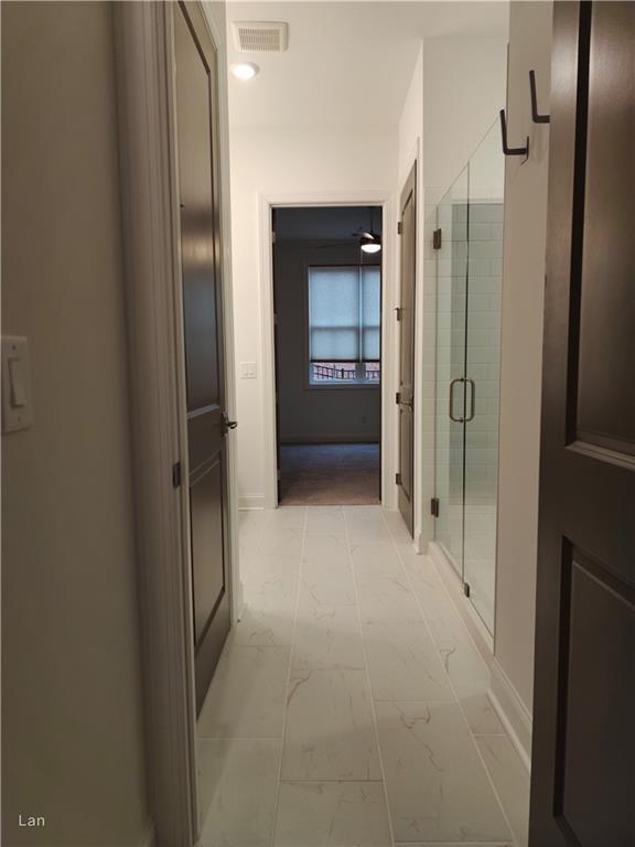 hall featuring marble finish floor, baseboards, and visible vents