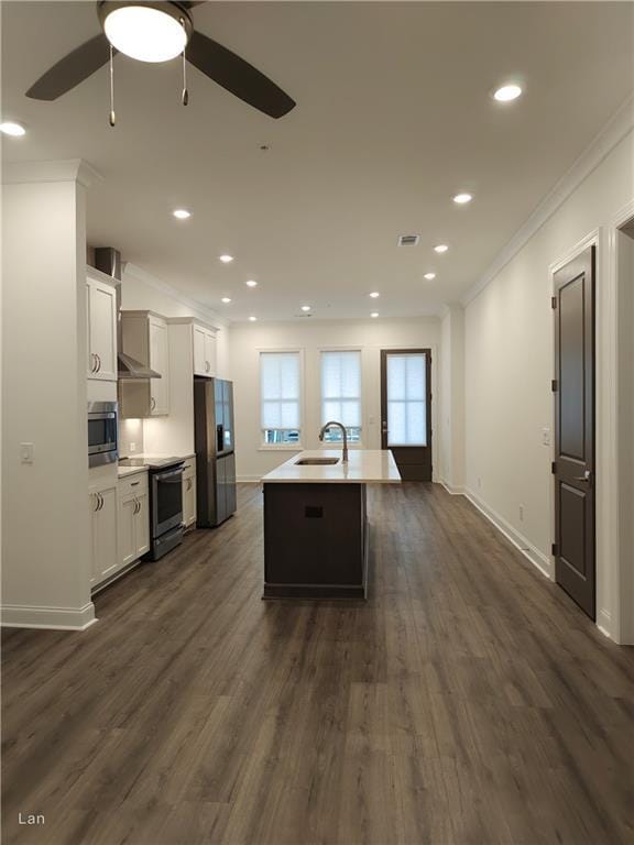 kitchen with a center island with sink, visible vents, appliances with stainless steel finishes, ornamental molding, and a sink