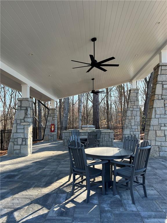 view of patio / terrace featuring fence, a ceiling fan, and outdoor dining space