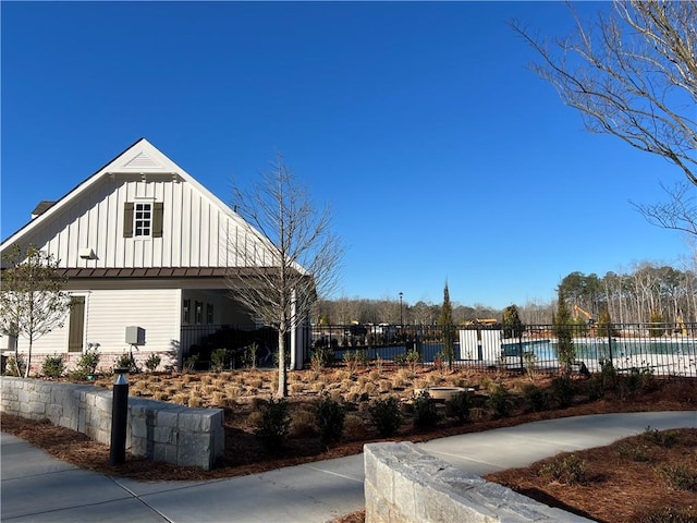 exterior space featuring board and batten siding and fence