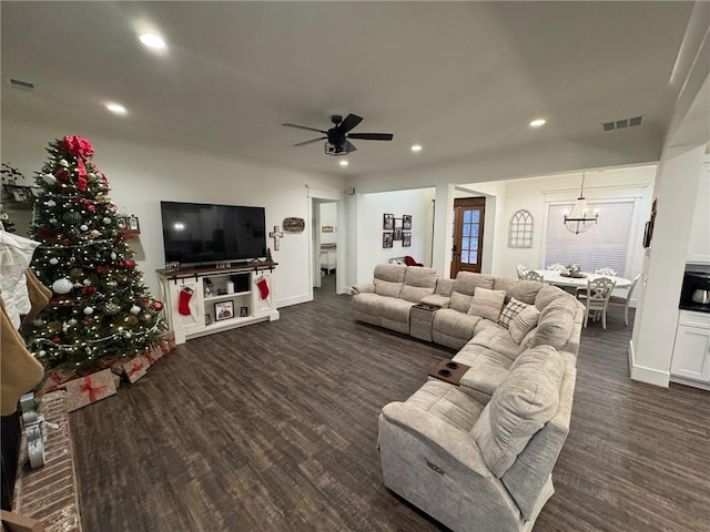 living room featuring ceiling fan with notable chandelier and dark hardwood / wood-style floors